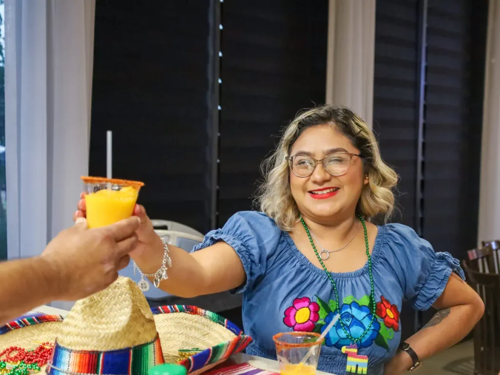 A happy woman holding juice at Houston Meeting venue - Up Above Venue