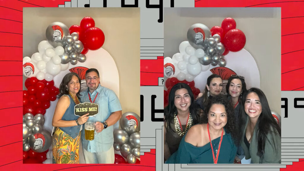 Classmates smiling together in front of a red, white and silver balloon arch at a class reunion at Up Above Venue in Houston
